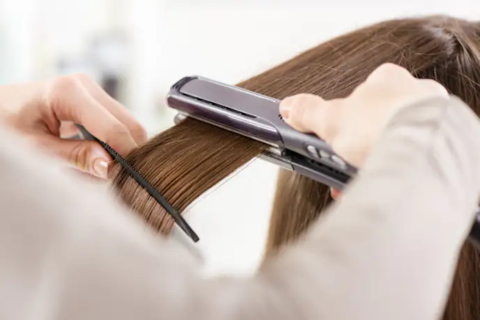 ヘアアイロンをかける女性